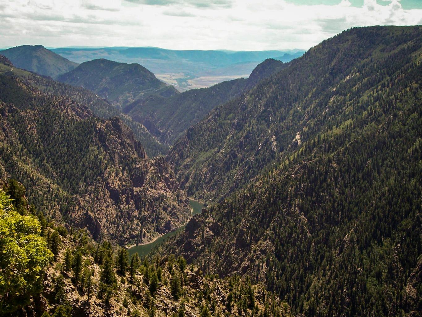 Scenic mountain view overlooking lush valleys, promoting an active outdoor lifestyle, hiking adventures, and nature exploration